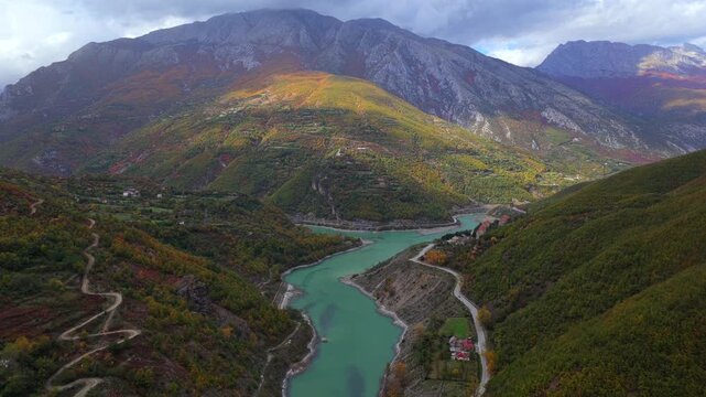Aerial video of Fierza Lake and winding mountain roads between lush valleys, marking the border area of Shkod&euml;r and Kuk&euml;s counties.