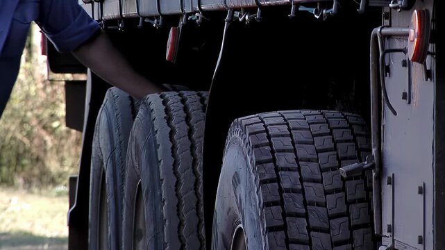 Professional Truck Driver Checking Tire Condition Before Trip, Road Safety Concept - 4K