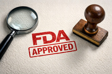 'FDA APPROVED' stamped on textured paper, beside a magnifying glass and wooden rubber stamp, symbolizing certification, quality assurance, and regulatory approval 