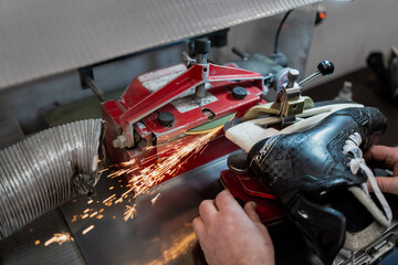 Professional hockey skate sharpening machine grinding blade with visible sparks, demonstrating elite team equipment maintenance and precision ice hockey service operations