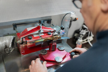 Automatic hockey skate sharpening workstation operated by professional equipment manager, focused on precision servicing and team level ice hockey maintenance