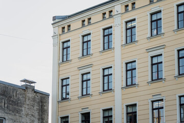 Classic residential apartment building exterior with restored facade and windows, highlighting urban housing renovation and architectural construction sector