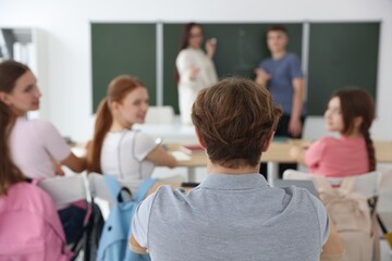Teacher and students during lesson in classroom, selective focus