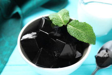 Tasty herbal jelly with mint leaves served on light blue table, closeup © New Africa