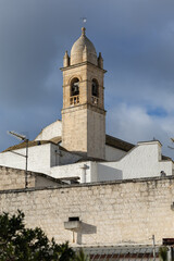 Fototapeta premium scenic view of a limestone church bell tower in puglia italy under a moody sky featuring traditional mediterranean architecture and ancient stone masonry details