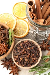 Different spices, fresh rosemary and dry orange slices for mulled wine on white table, flat lay