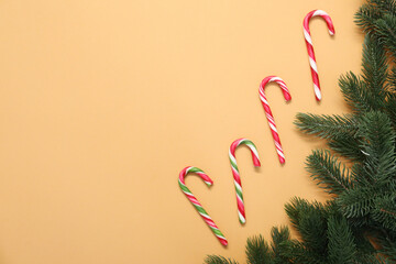 Obraz premium Flat lay composition with candy canes on pale orange background, space for text. Christmas treat