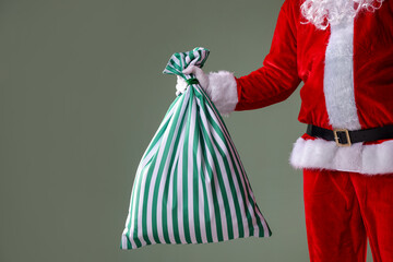 Santa Claus holding sack on grey background, closeup with space for text. Merry Christmas and Happy New Year © New Africa