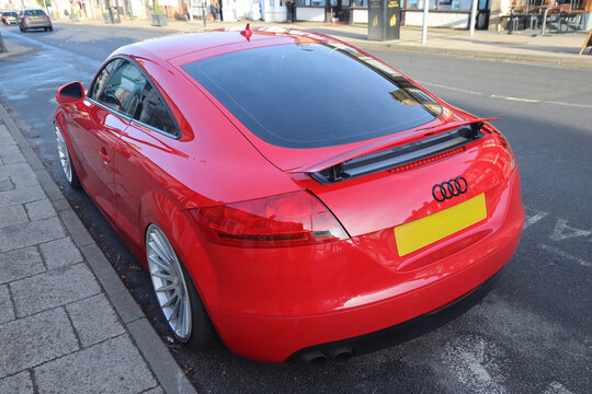 Norwich, england november 26 2025 red audi sports car parked on a wet street with a yellow license plate