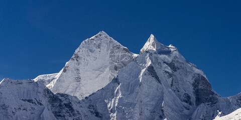 Obraz premium Thamserku peak behind Kangtega and under blue sky. Panoramic view from Thukla (Dughla) on Everest base camp trekking, Nepal.