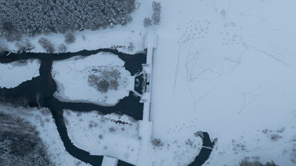 Aerial dam and sluice divide river and reservoir in Belarus winter