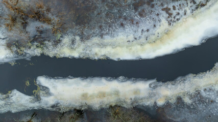 Aerial river between thawing ice bands in rural Belarus winter
