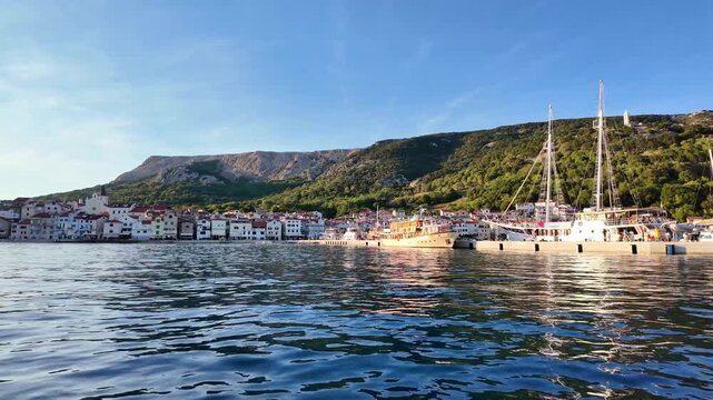 Tranquil maritime harbor with sailboats and waterfront architecture at sunset. Ba&scaron;ka, Krk island, Croatia