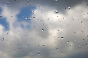 Raindrops On Window With Cloudy Sky