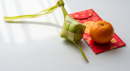 Vibrant symbols of Asian celebration Ketupat, lucky packet, and citrus