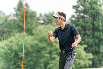 Male golfer pumping his fist at the golf course