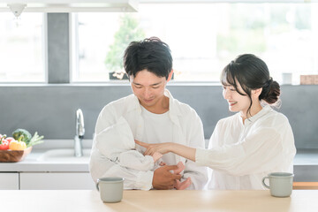 A young couple soothing their baby in the living/dining room