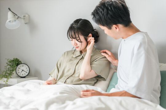 A woman suffering from tinnitus, dizziness, hearing loss, and otitis media and a worried man