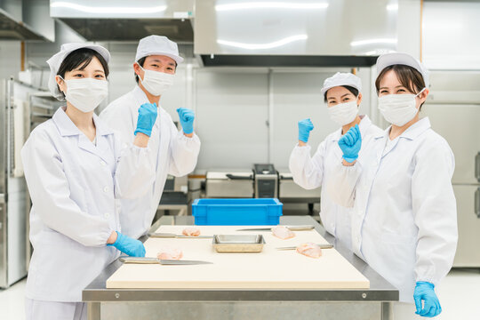 Male and female staff in chef coats preparing chicken (chef, chef, fresh market, food processing)
