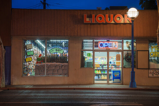 LOS ANGELES, CA - December 25, 2025: Illuminated Liquor store front facing Santa Monica Blvd at night.