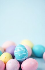 Naklejka premium Group of pastel colored Easter eggs gathered on pale blue background. One bright blue egg with white swirls stands out. Festive spring holiday tradition.