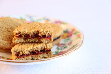 Close-up of strawberry cookies on a vintage plate with flowers design. Delicious soft biscuits and comforting treats. Food  and dessert for a snack. 