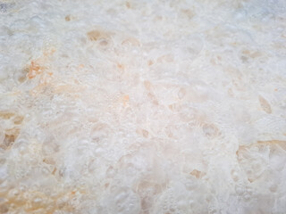 white bread crumb texture with soft porous details, photographed indoors in natural light. Abstract food background showing baked bread surface, freshness, and texture.