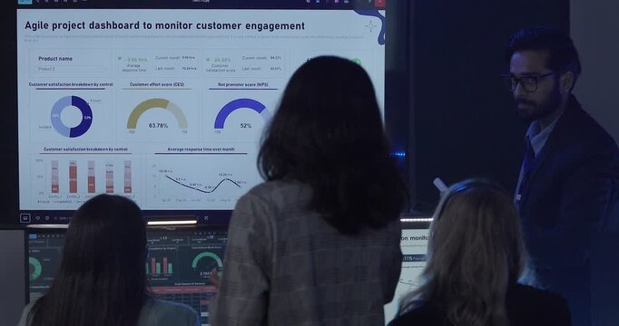 A focused team wearing headsets monitors live analytics dashboards and collaborates in modern control room. Highlighting customer support, data driven decision making, coordinated incident response.
