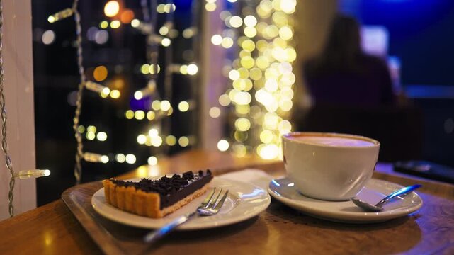 Silent evening meal with city backdrop, Late night beverage and pastry set against glowing cityscape