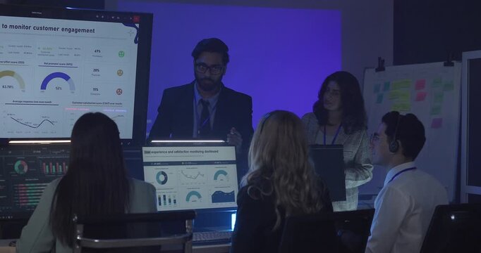 A focused team wearing headsets monitors live analytics dashboards and collaborates in modern control room. Highlighting customer support, data driven decision making, coordinated incident response.
