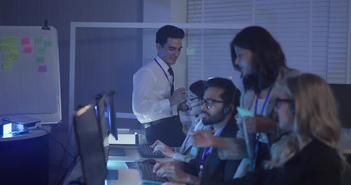 A focused team wearing headsets monitors live analytics dashboards and collaborates in modern control room. Highlighting customer support, data driven decision making, coordinated incident response.
