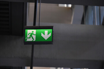Exit sign with running figure in a building hallway
