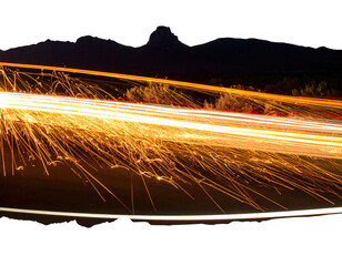 Long exposure shot of light trails against dark mountain backdrop