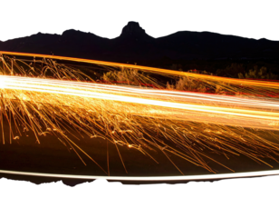 Long exposure shot of light trails against dark mountain backdrop