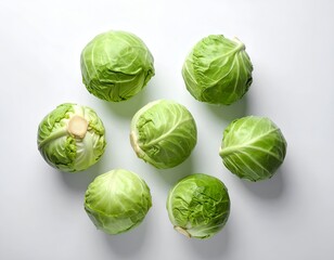 Fototapeta premium Seven vibrant green cabbages arranged in a circle on a white surface