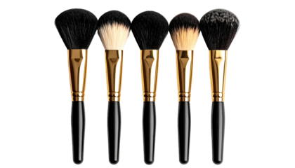 Five makeup brushes in a row, with black and gold handles, white backdrop