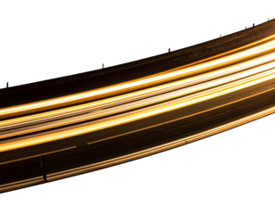 Curved road with streaks of light against a black night sky