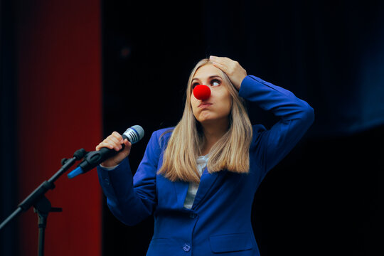 Woman with Clown Nose Saying Silly Things at the Microphone. Politician making a fool out of herself trying to speak to an audience 
