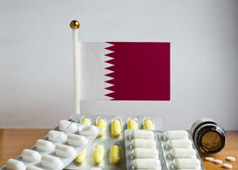 Flag of Qatar with Pills and Capsules. Pharmaceutical Concept
