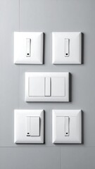 Five white light switches mounted on a gray wall in a neat pattern, showcasing modern electrical fixtures