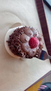 Close-up of a fork cutting through a soft, creamy layer of cake, delicious dessert being served.