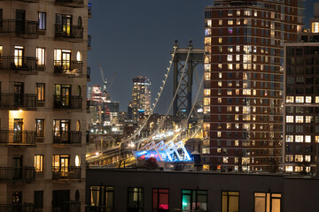 Manhattan skyline at night viewed from Brooklyn with illuminated skyscrapers and city lights