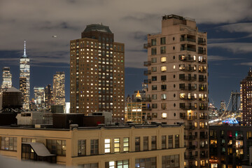 Manhattan skyline at night viewed from Brooklyn with illuminated skyscrapers and city lights