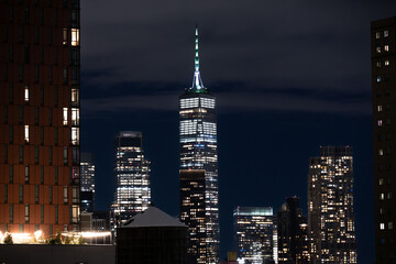 Manhattan skyline at night viewed from Brooklyn with illuminated skyscrapers and city lights