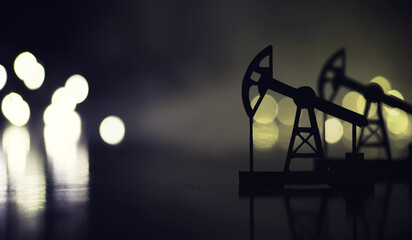 In the evening, the silhouette of oilfield derrick. Beam pumping unit under the night, closeup of photo
