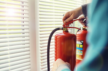 Fire extinguisher has hand engineer inspection checking pressure gauges to prepare fire equipment for protection and prevent emergency and safety rescue and alarm system training concept.