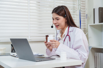 Asian female doctor wearing headset smiling while explaining medicine usage to patient during telemedicine consultation providing healthcare advice through digital telehealth communication