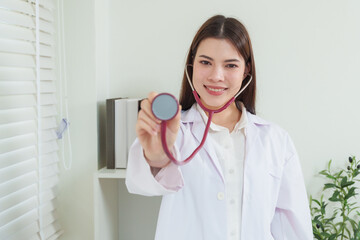 Confident asian female pediatric doctor smiling warmly holding stethoscope forward representing professionalism healthcare trust medical expertise pediatric care treatment and reliable consultation