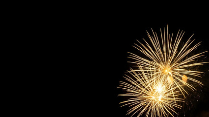 Obraz premium Dynamic golden fireworks illuminate the dark night sky, creating a mesmerizing spectacle of vibrant light trails and explosive energy, a breathtaking moment of joyous celebration
