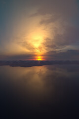 Obraz premium Serene Sunset Over Calm Lake With Mountain Range And Soft Clouds At Dusk